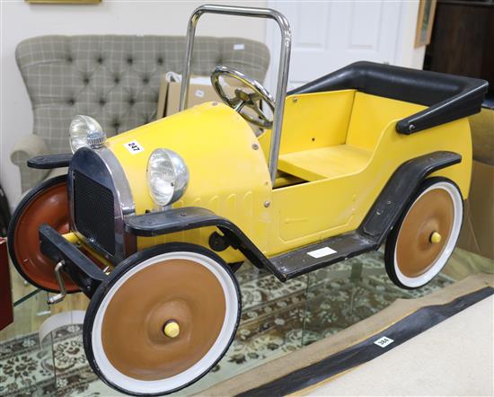 A yellow childs toy pedal car